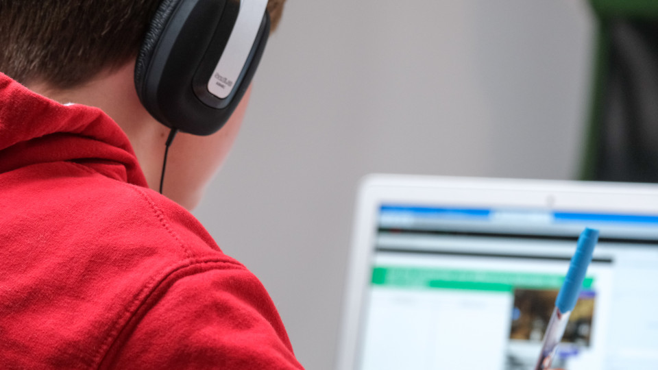 Schüler mit Headset vor Laptop