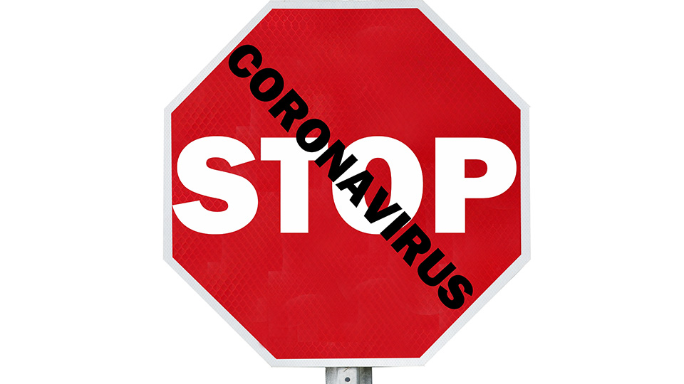 Stop-Schild und Schriftzug: Coronavirus davor