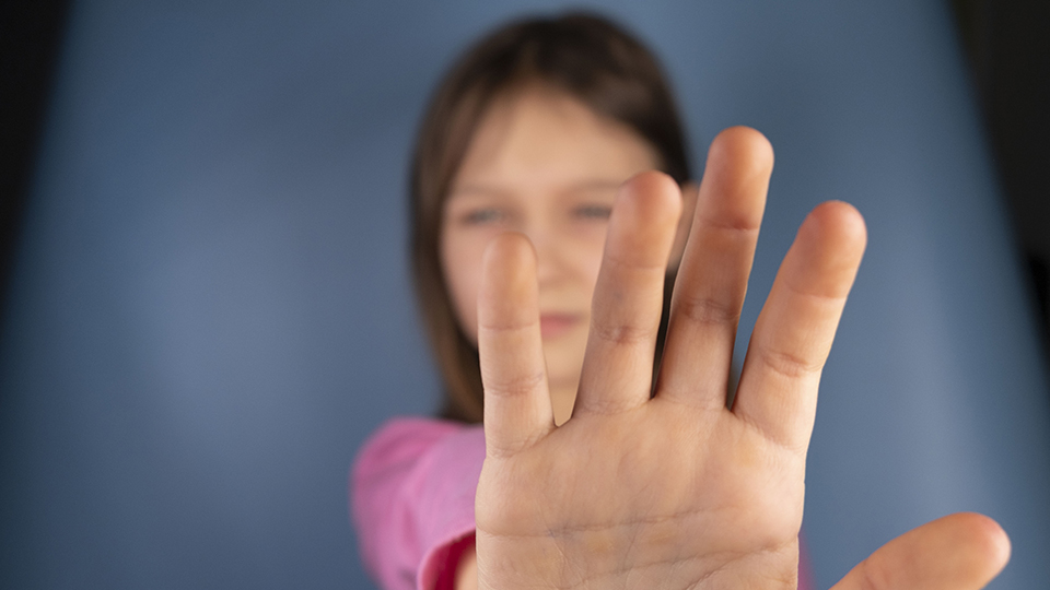 Mädchen, das ihre Hand nach vorne hält, um "nein" zu sagen