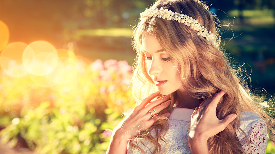 Braut mit Blumenkranz im Haar und Locken - romantischer Look