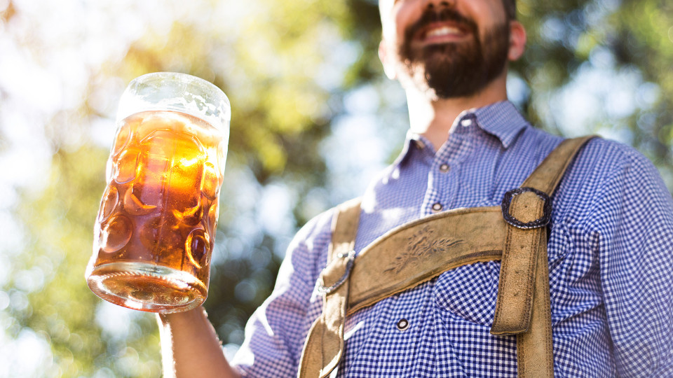 Mann hält ein Bier