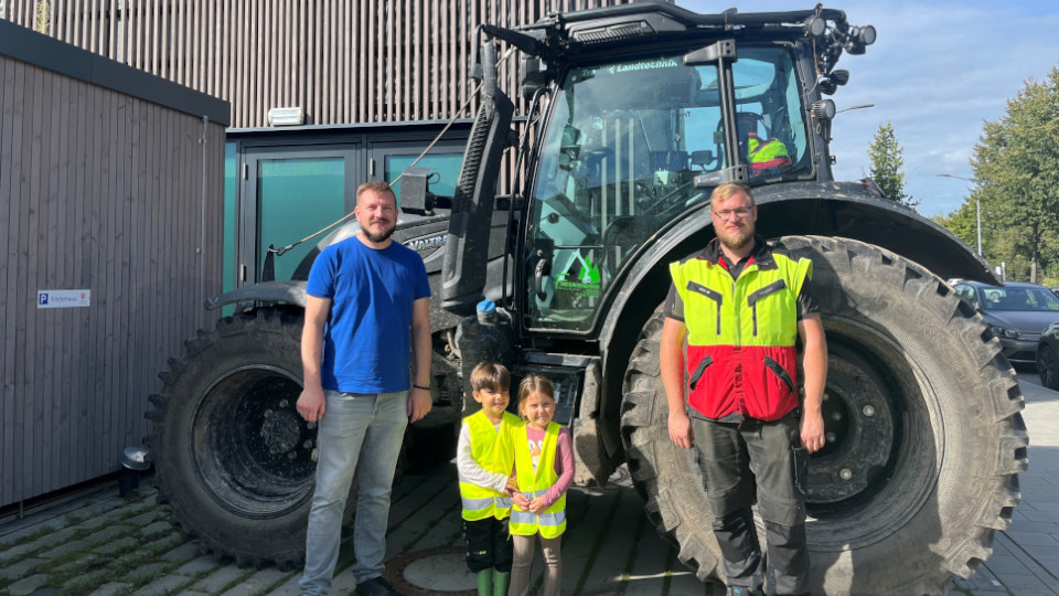 Kinder stehen vor dem Traktor