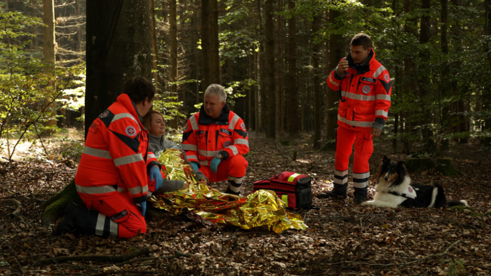 Rettungssanitäter im Wald mit einem Hund