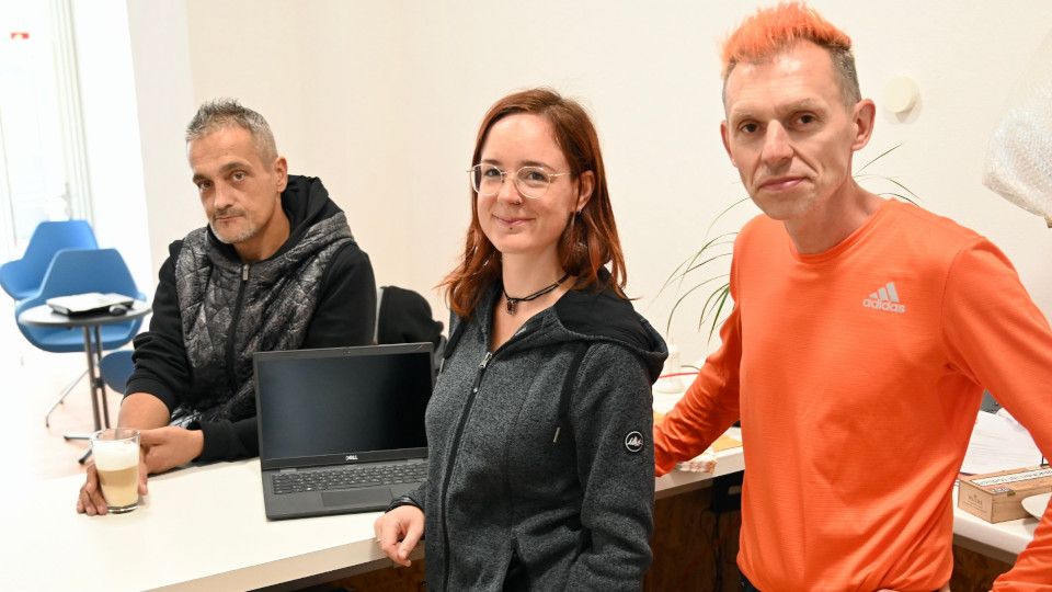 Die Caritas Streetworker Ben Peter und Olivia Mantwill mit einem Besucher im StreetNetCafé. 