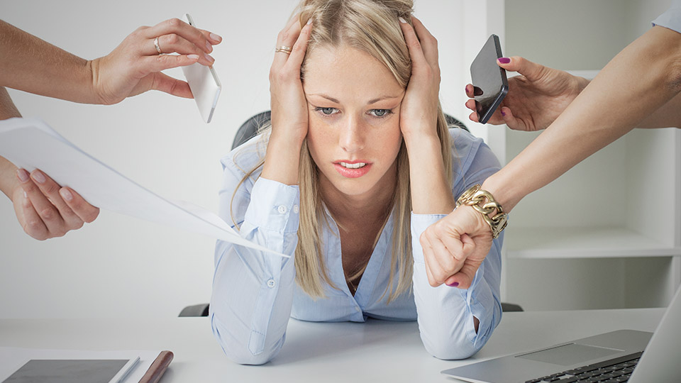 Depressionen im Arbeitsumfeld: Erschöpfte Frau, die von Kollegen mit Aufgaben belagert wird