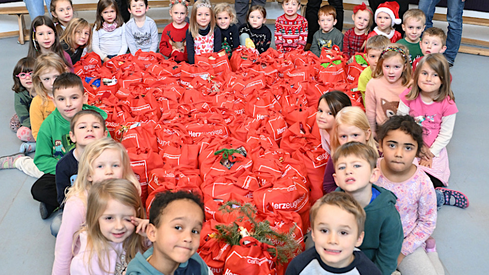 Zusammen mit den Erzieherinnen hatten die Kinder des Kindergartens St. Martin ein großes Herz aus den roten Caritas-Geschenketaschen geformt