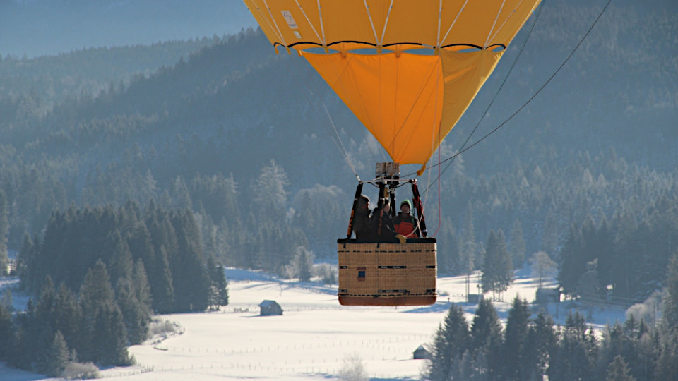 Heißluftballon schwebt über dem Schnee