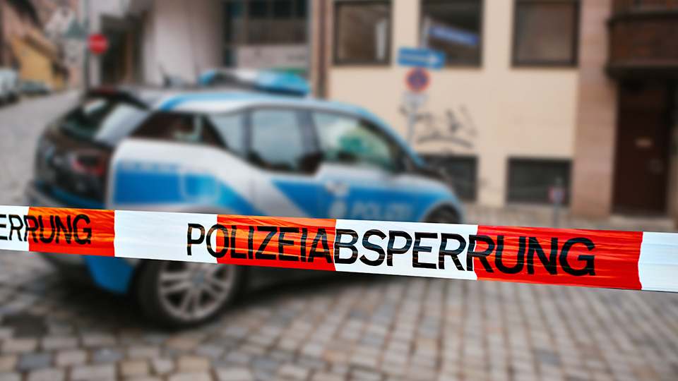 Streifenwagen der Polizei hinter Polizeiabsperrung